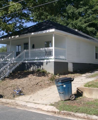 A street view of a one-story white house at 601 Gray Avenue.