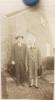 Two people outside the house. Perhaps Bud and Thelma Davis